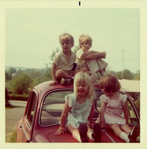 children sitting on old VW bug