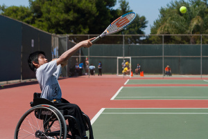 boy in wheelchair playing tennis